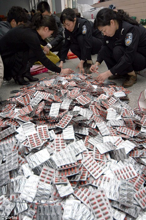 Crackdown: Chinese officials, pictured confiscating thousands of illegal tablets, say they will clampdown on the massive herbal medicine industry which has seen dangerous bacteria an human remains added to seized pills